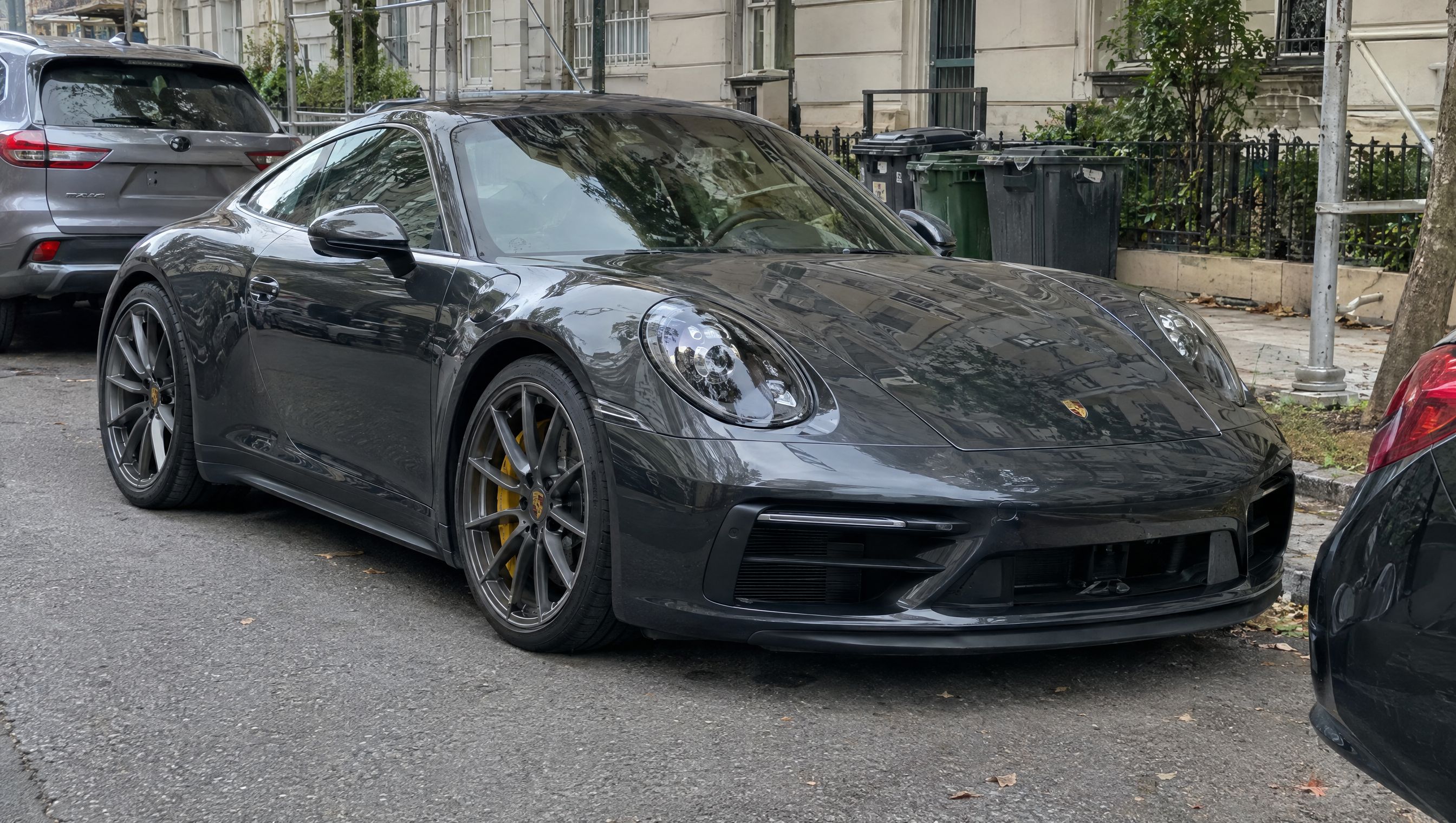 Graphite sports coupe parked on a city street, the original photo before the background is changed