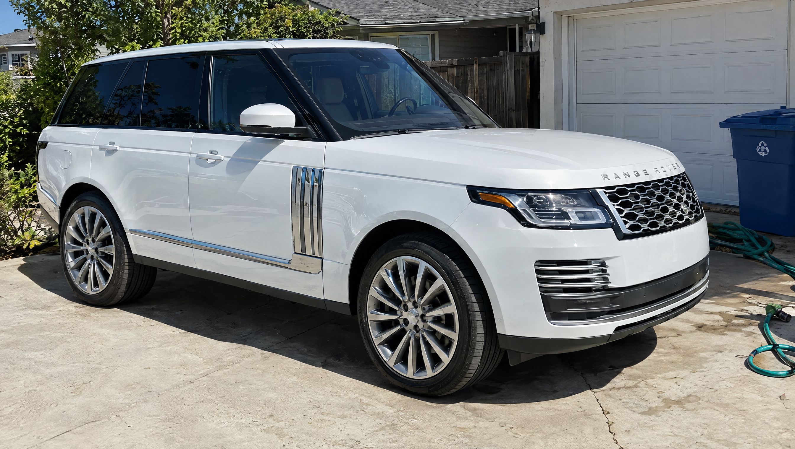 White luxury SUV parked in a sunlit driveway: the original photo before the background change